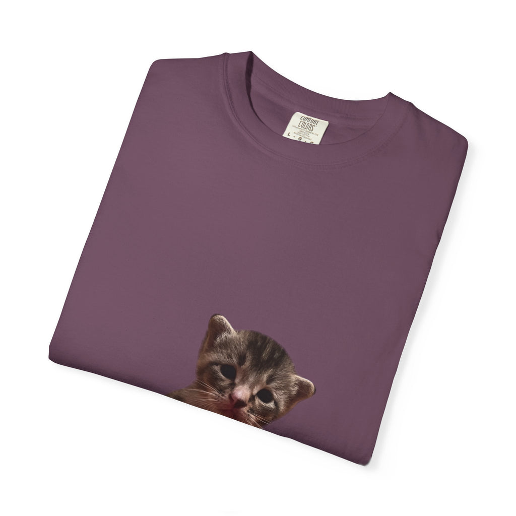 Folded purple t-shirt with a cat face print on a white background