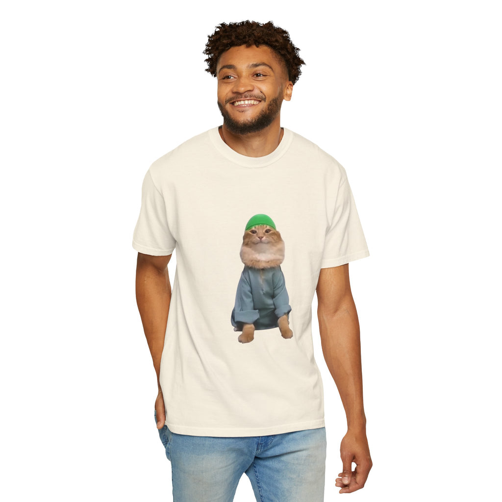 Man wearing a cream t-shirt with a graphic of a cat in a green hat and blue jacket on a white background