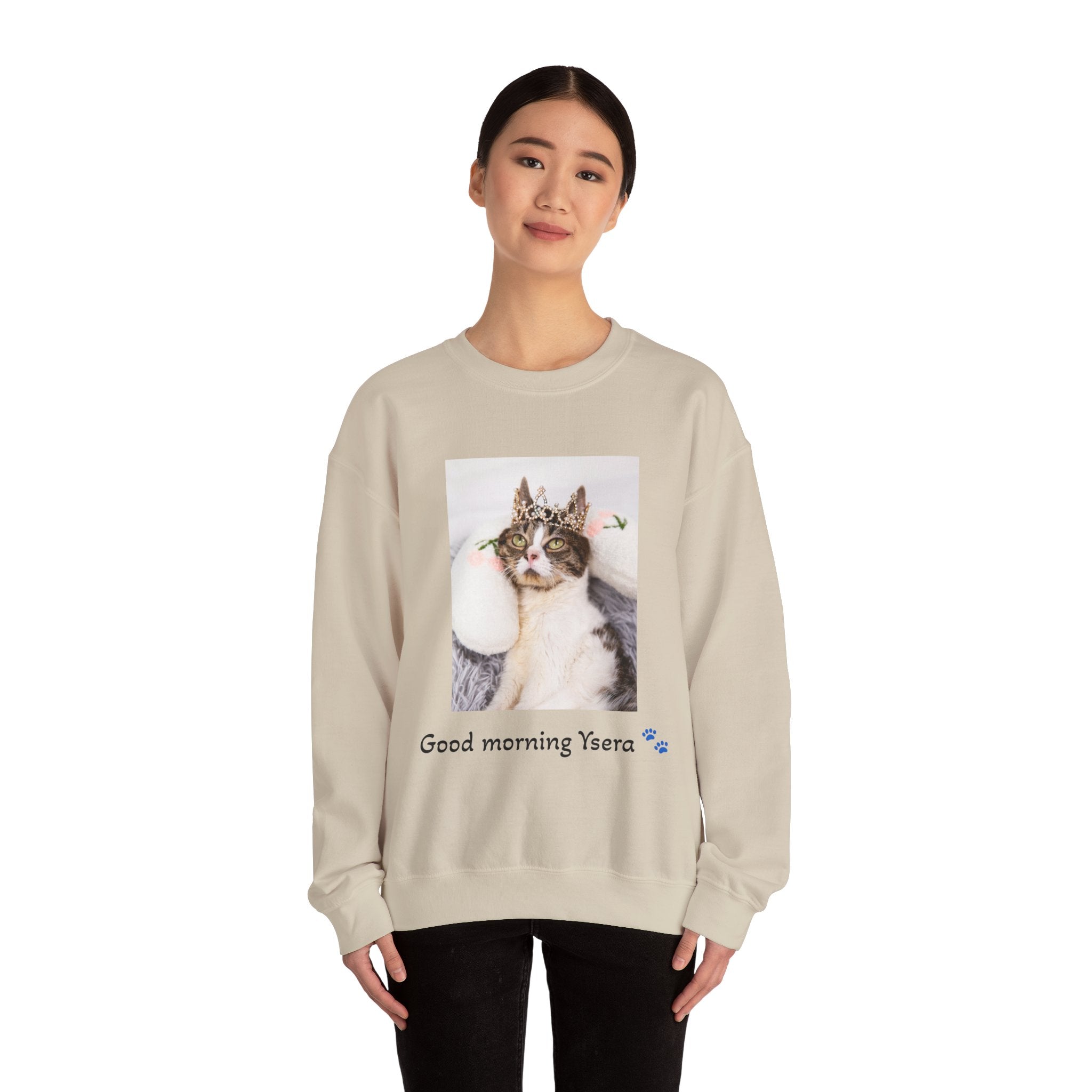 Person wearing a beige sweatshirt with a cat graphic and text on a white background