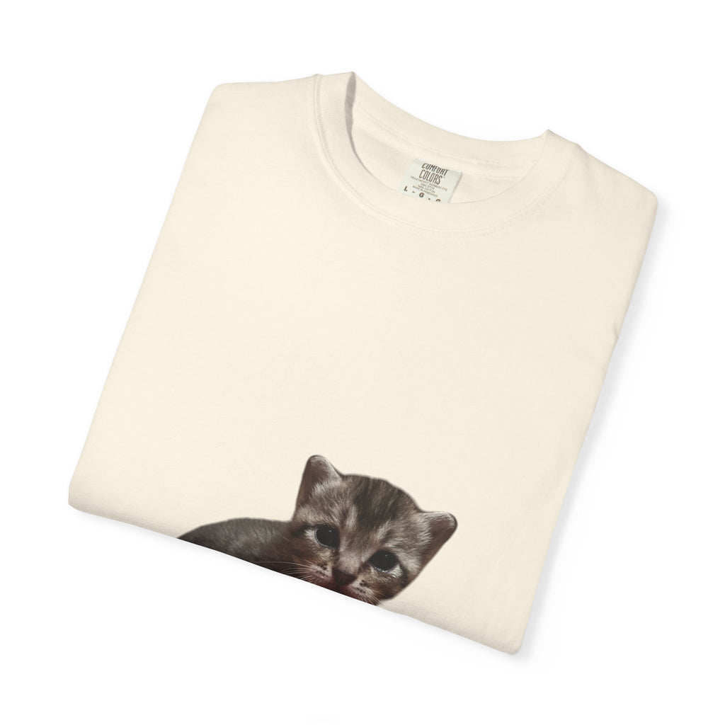 Folded cream-colored t-shirt with a kitten print on a white background