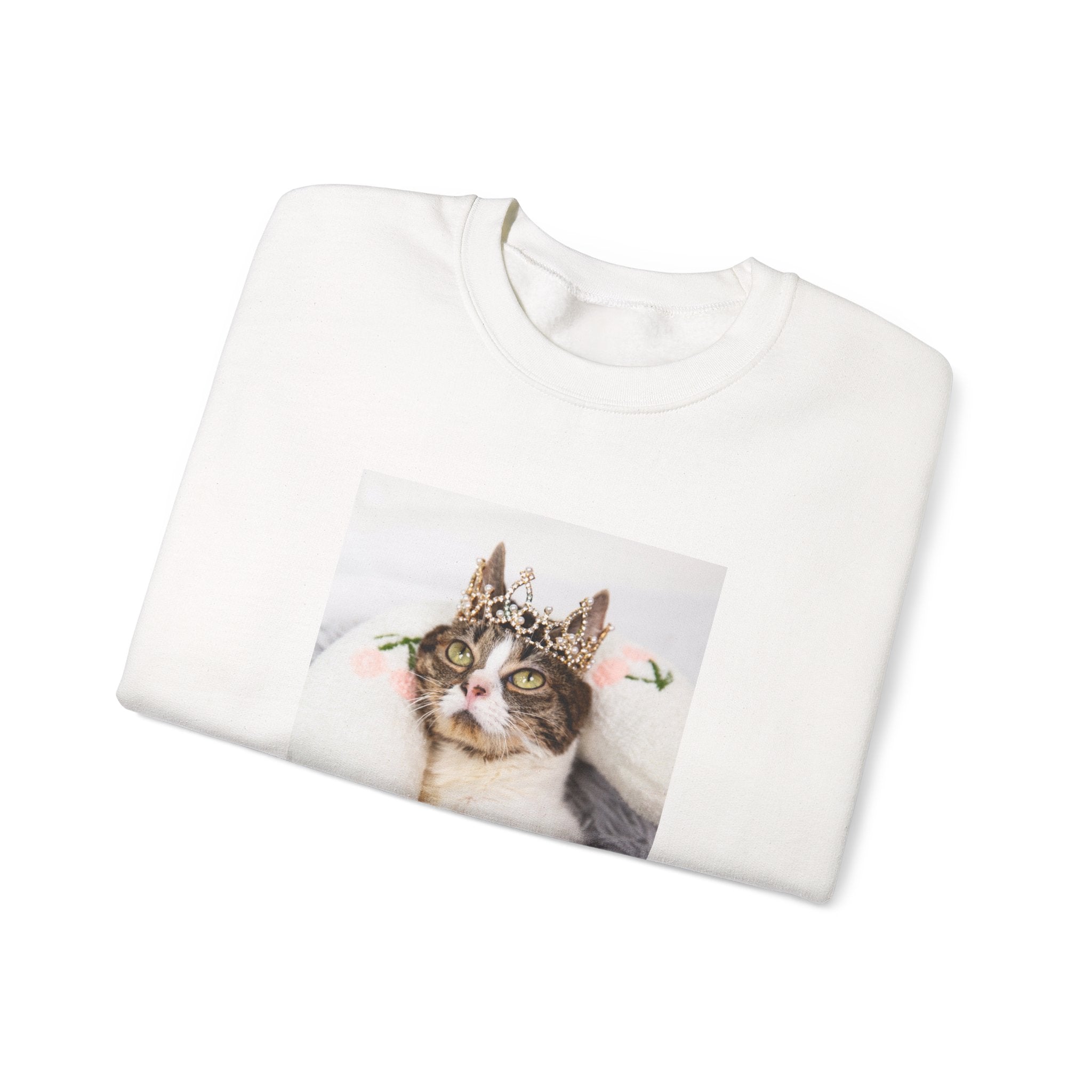 White sweatshirt with a cat wearing a crown printed on it, folded and displayed against a white background.