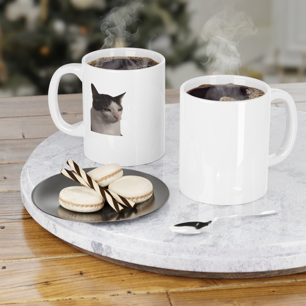 Two white mugs with coffee and a cat picture on a marble tray with cookies.