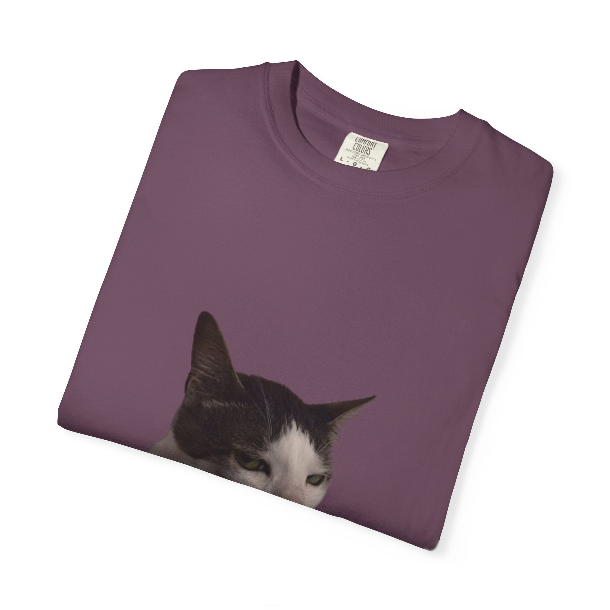 Folded purple t-shirt with a cat's face print on a white background