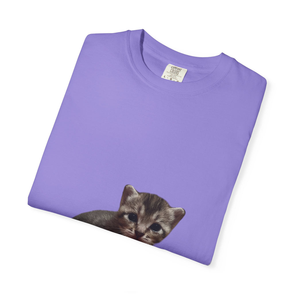 Folded purple t-shirt with a kitten graphic on a white background