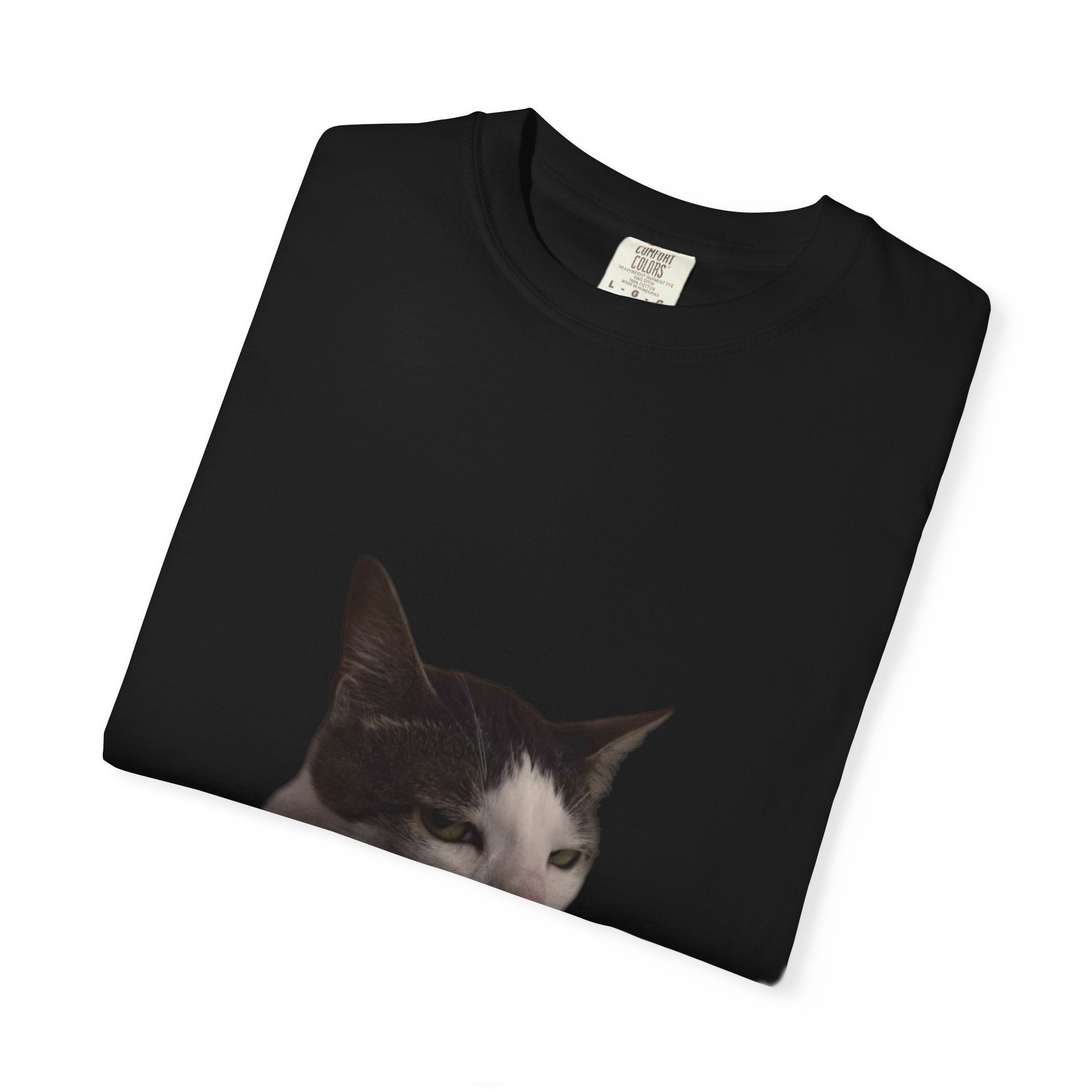 Black t-shirt with a cat's face printed on it, folded on a white background