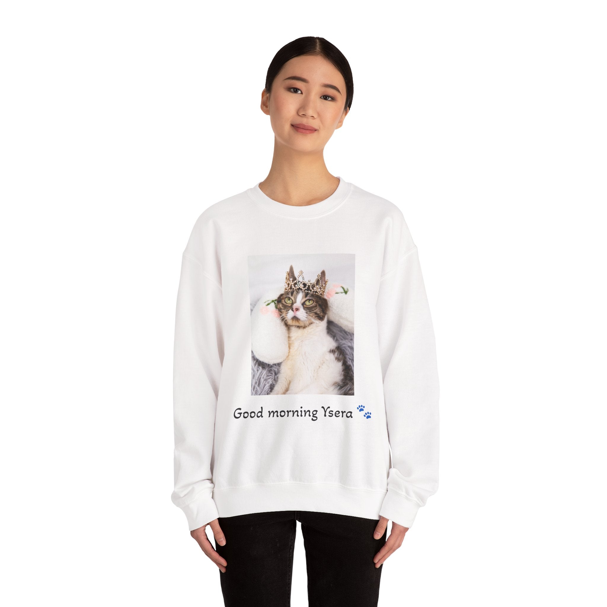 Person wearing a white sweatshirt with a cat graphic and text on a white background