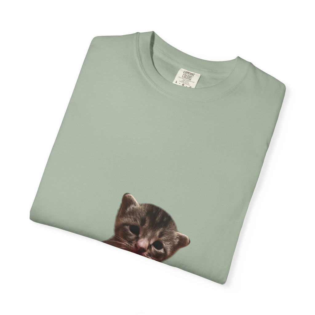 Folded light green t-shirt with a cat graphic on a white background