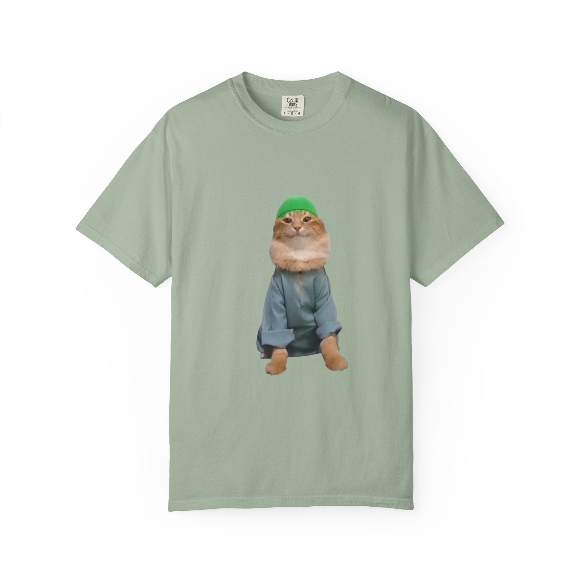 Light green t-shirt with a graphic of a cat wearing a green hat and blue jacket on a white background.