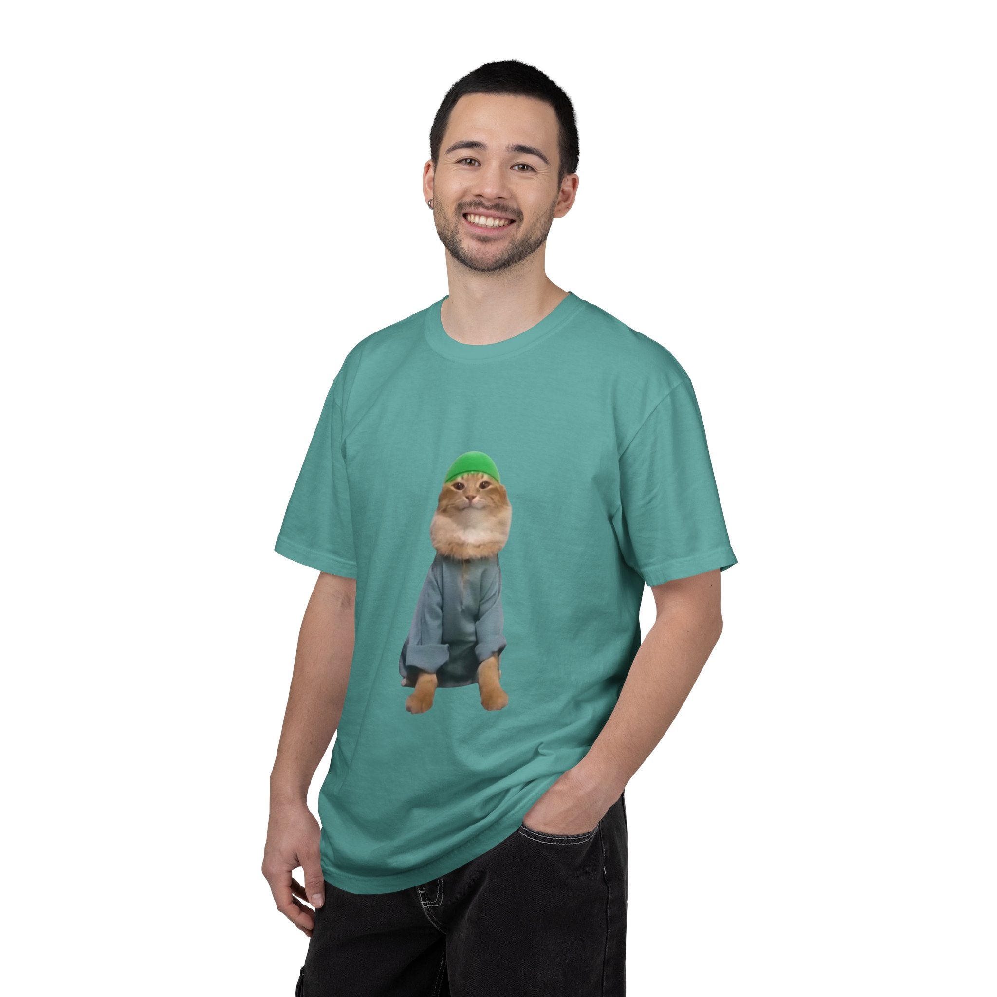 Man wearing a teal t-shirt with a graphic of a cat in a sweater and hat on a white background
