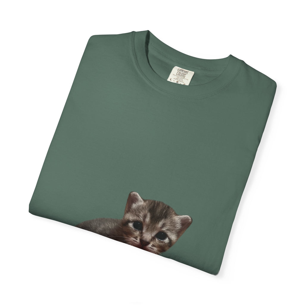 Folded green t-shirt with a kitten print on a white background