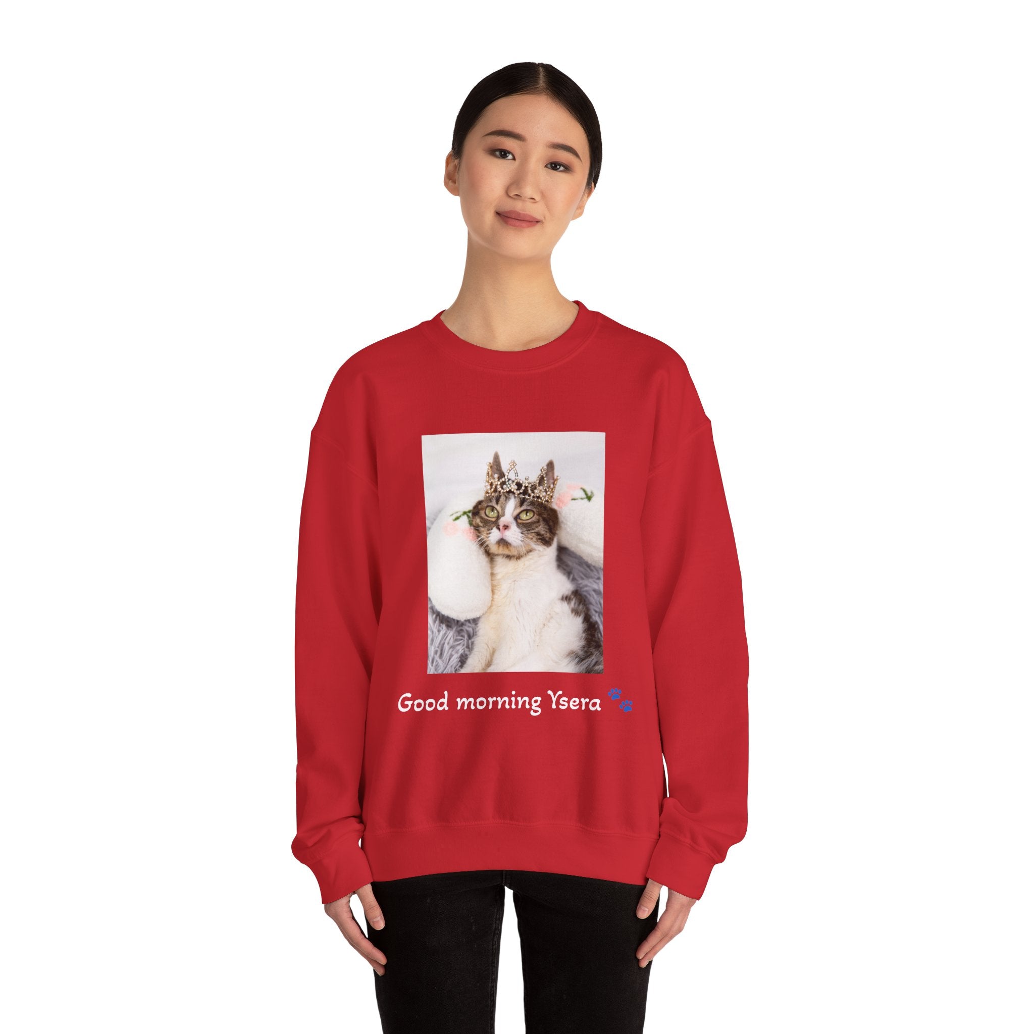 Person wearing a red sweatshirt with a cat graphic and text on a white background