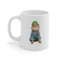 White mug with a cat wearing a green hat and gray outfit on a white background