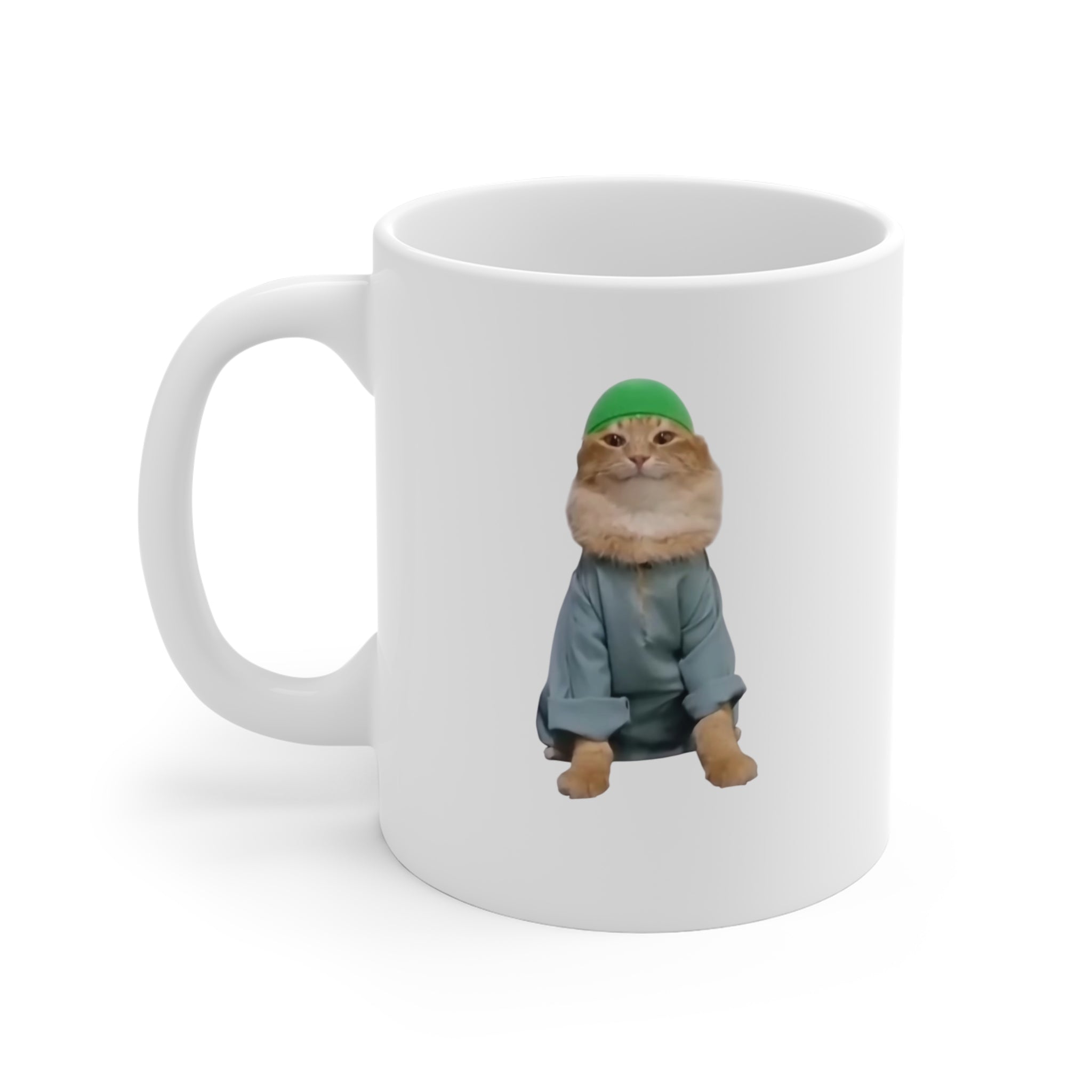 White mug with a cat wearing a green hat and gray outfit on a white background