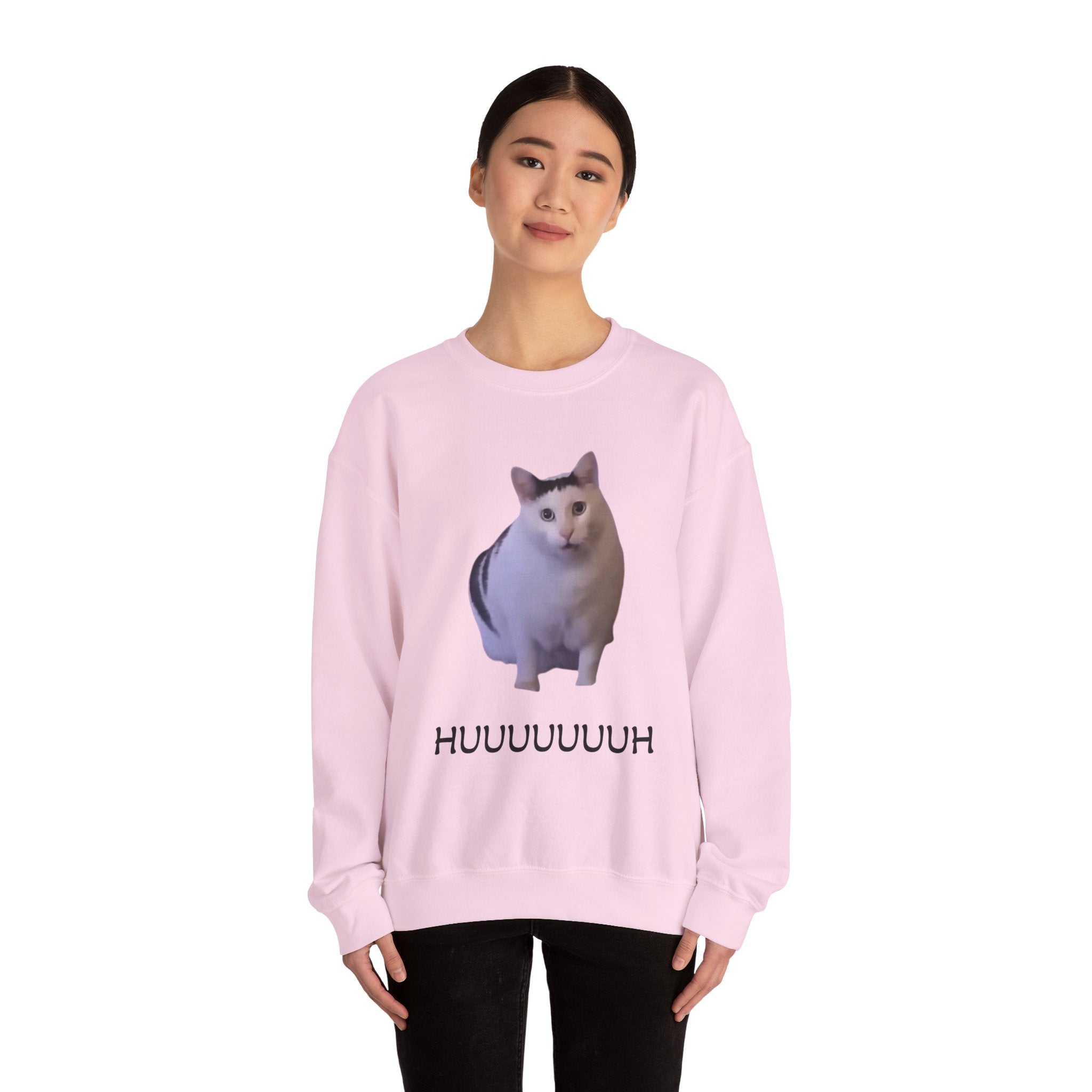 Person wearing a pink sweatshirt with a cat graphic and text on a white background