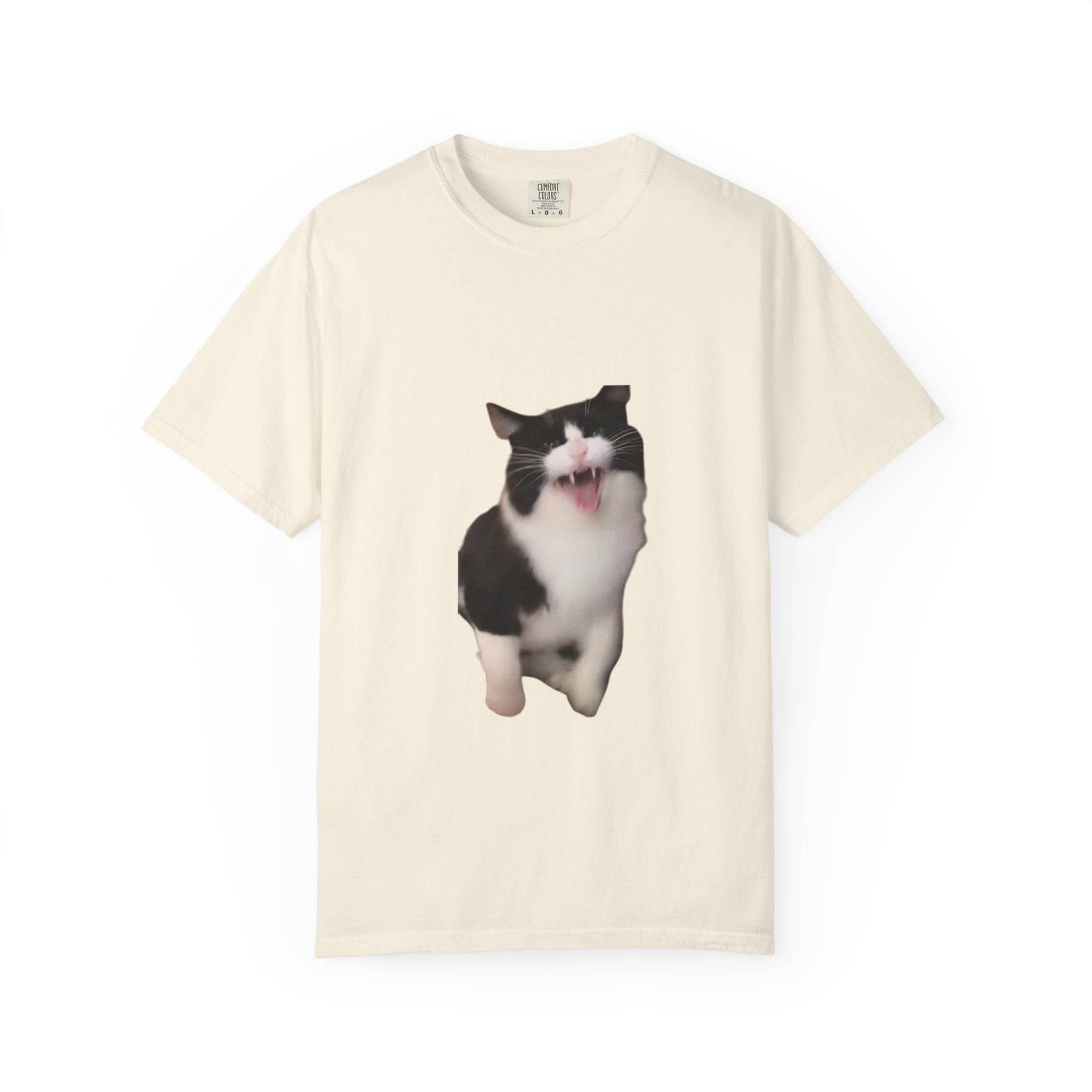 Beige t-shirt with a black and white cat graphic on a white background