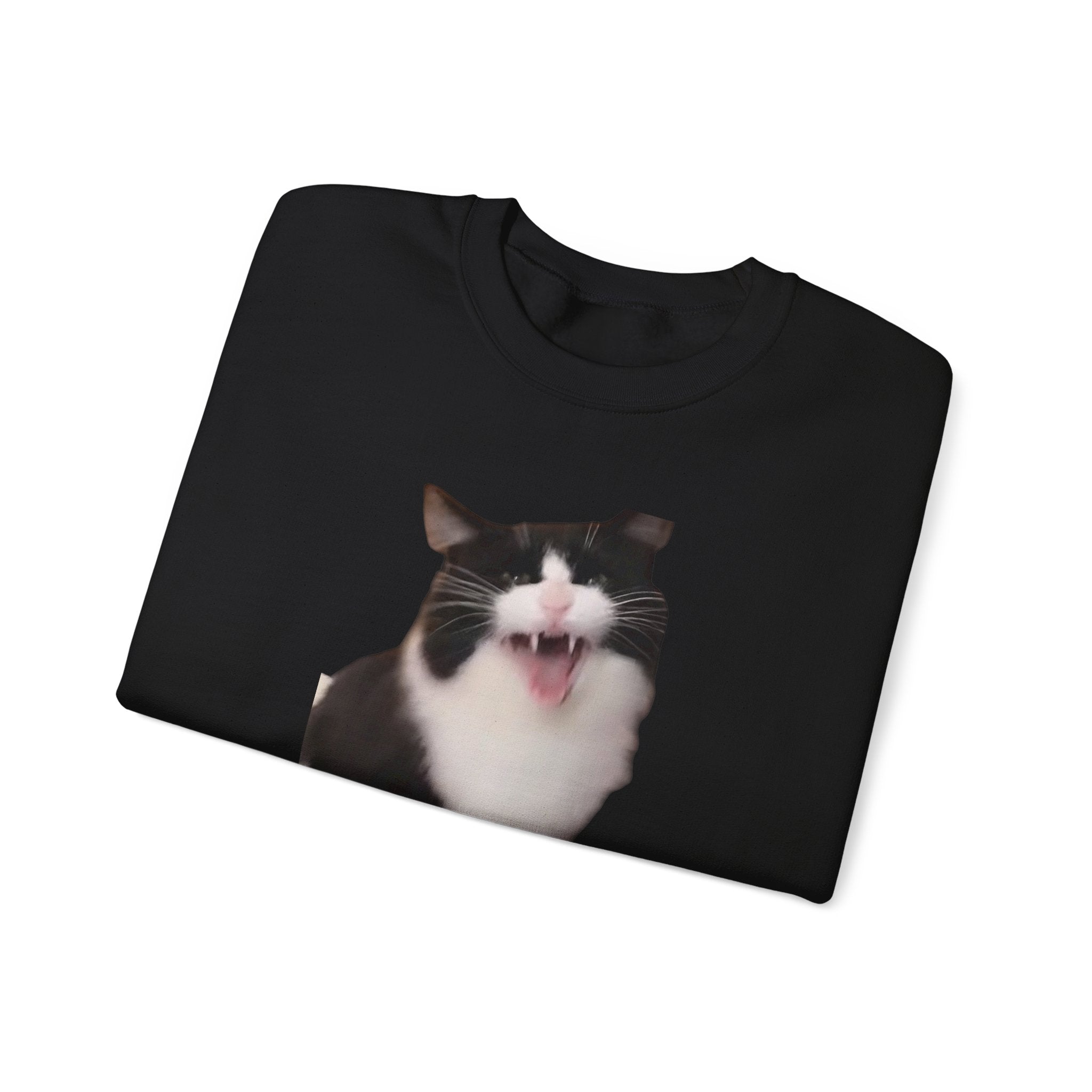 Black sweatshirt with a cat's face printed on it, folded on a white background