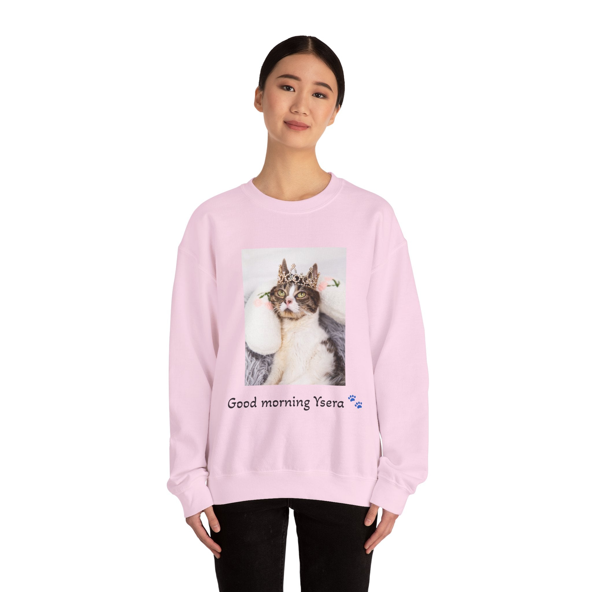 Person wearing a pink sweatshirt with a cat graphic and text on a white background