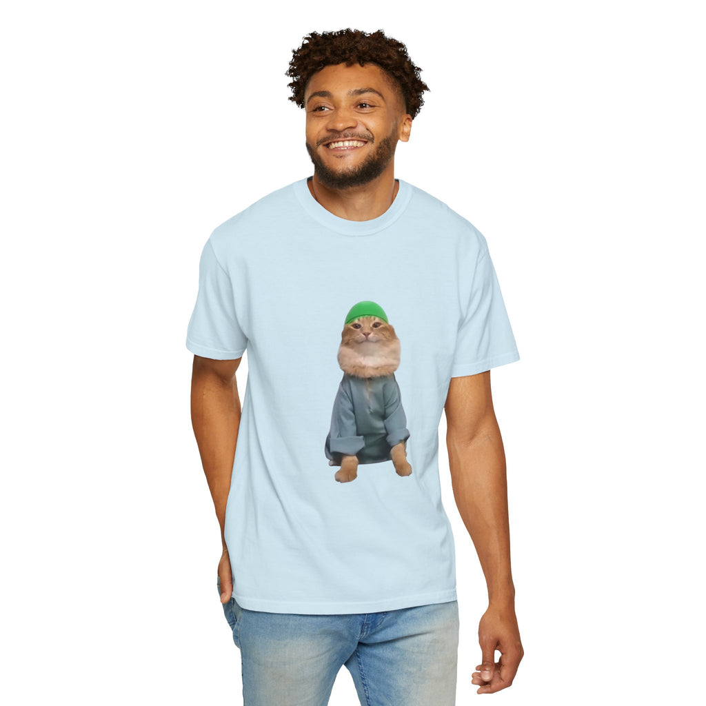 Man wearing a light blue t-shirt with a graphic of a cat in a green hat and gray outfit on a white background