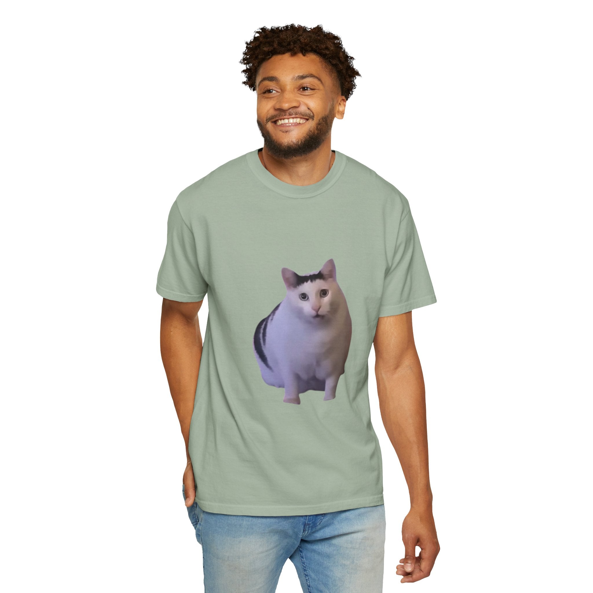 Man wearing a light green t-shirt with a cat graphic on a white background