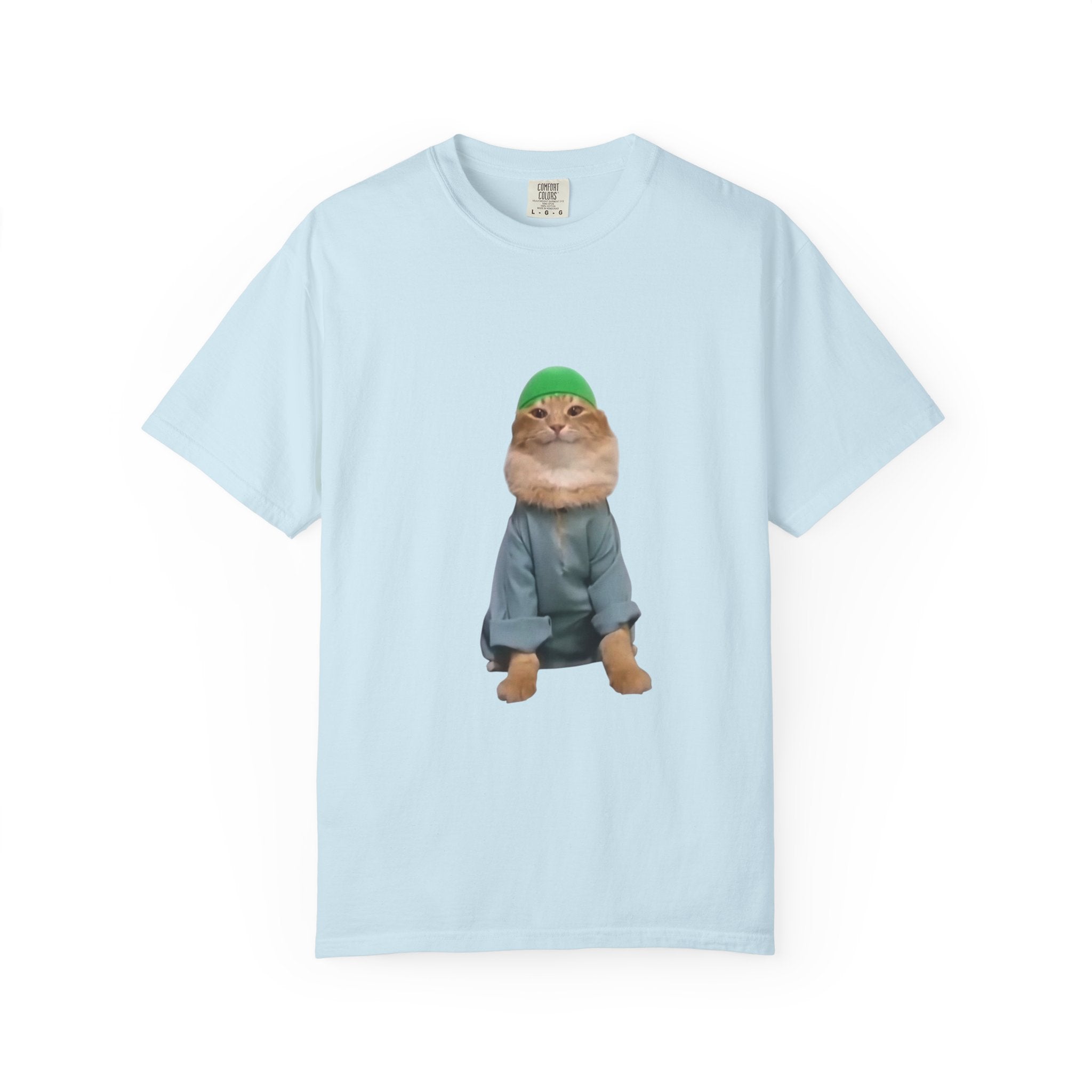 Light blue t-shirt with a graphic of a cat wearing a green hat and gray outfit on a white background.